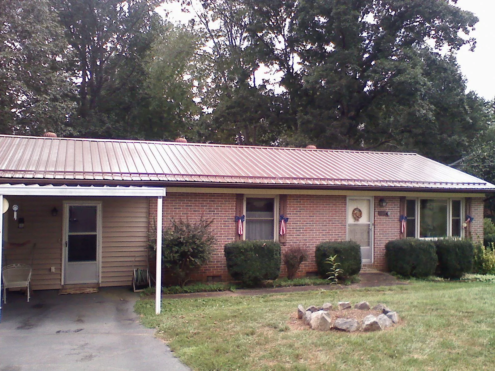 Bronze metal roof and carport on a brick ranch home — Roof Repair work by our crew in Concord